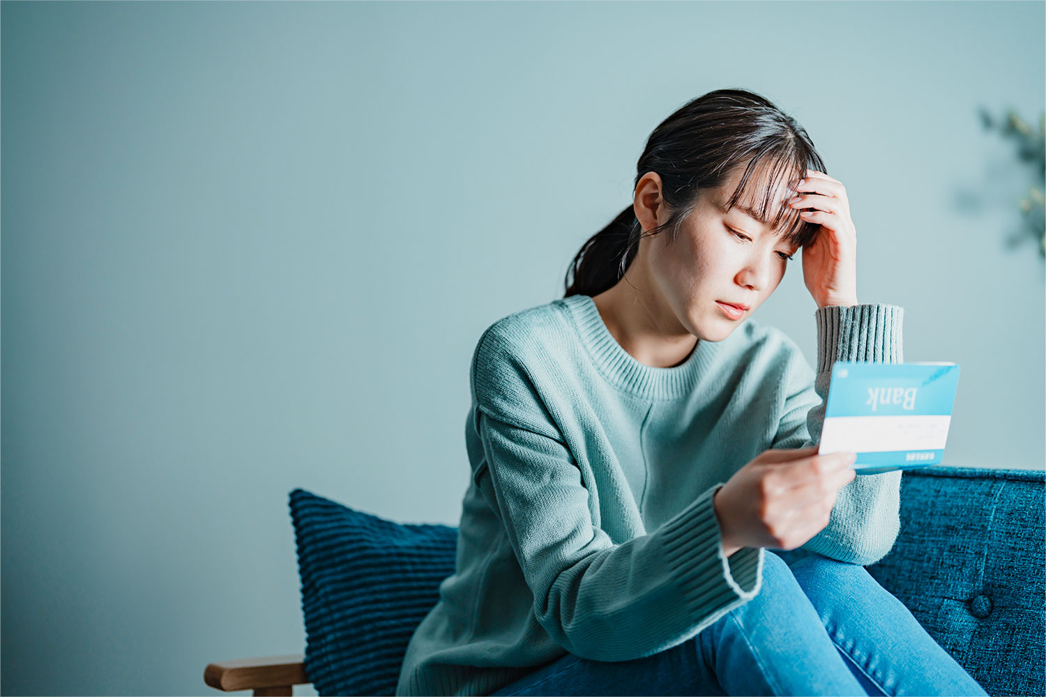 家計の書類を前に、お金のことで悩む様子